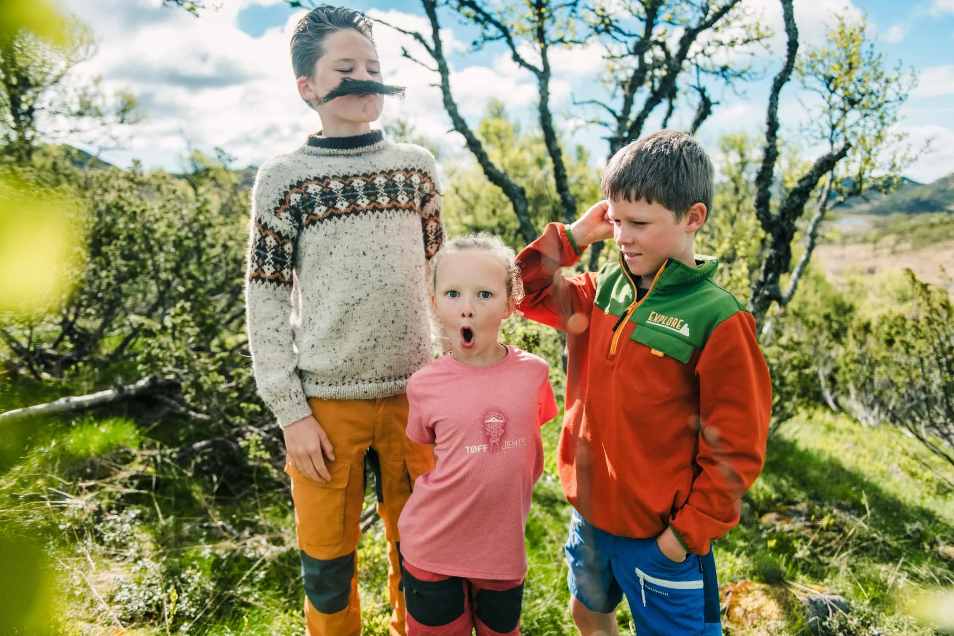 Tre barn tuller på fjelltur i bjørkeskogen ved Rauland