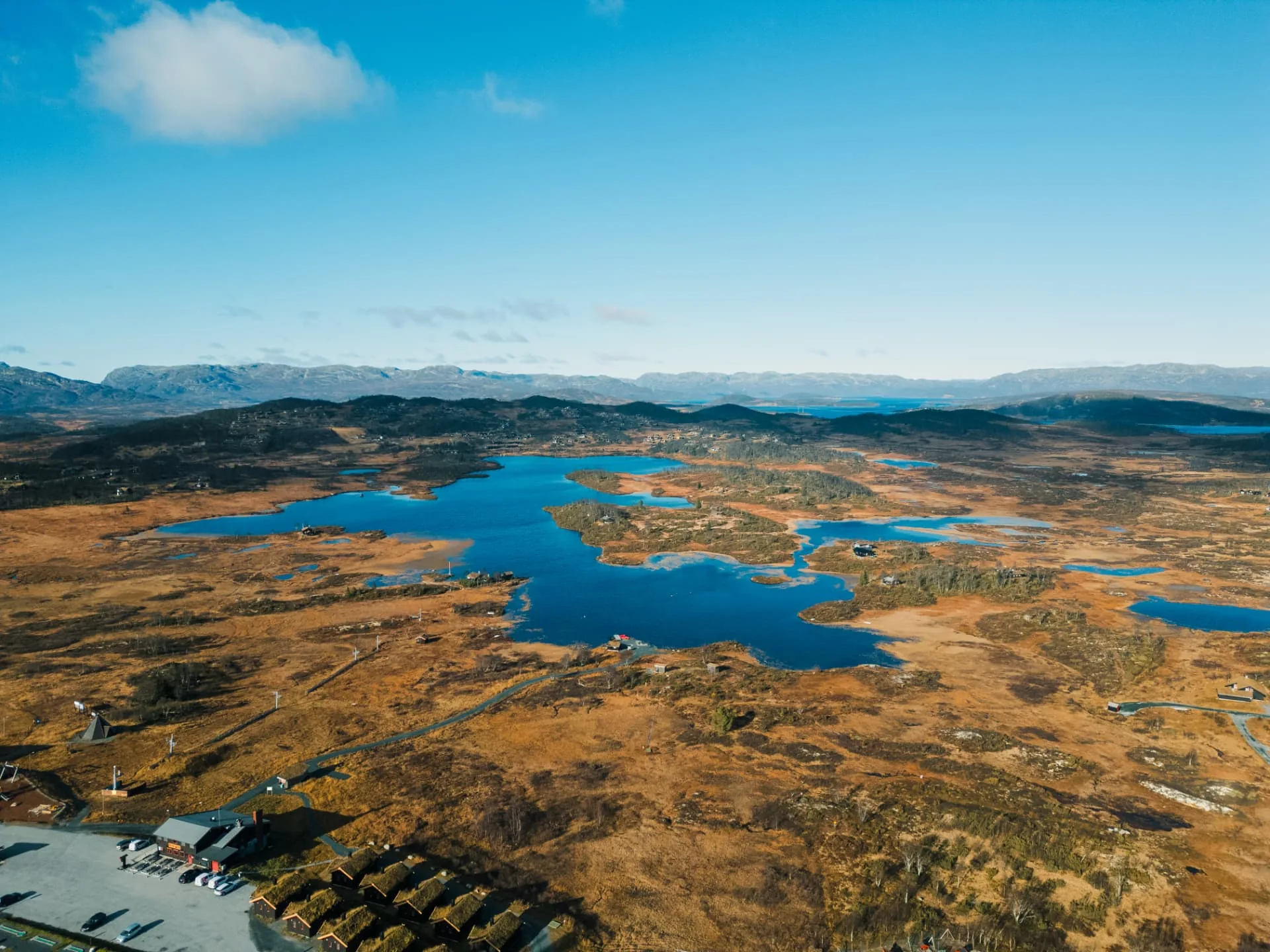 Dronebilde over vidda ved Rauland med hytter og fjellvann i høstfarger