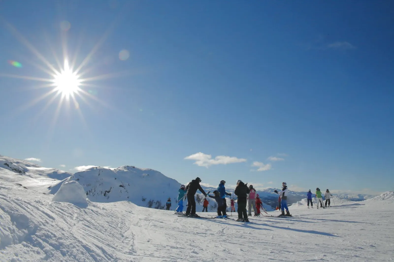 Skiglade gjester i alpinbakken ved Rauland Skisenter en solfylt vinterdag