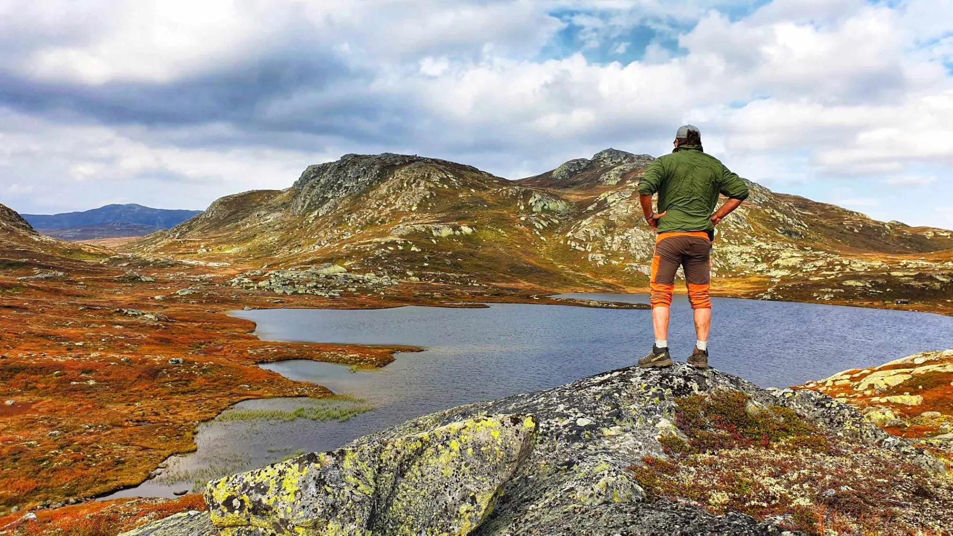 Vidstrakt Hardangervidda-platå med blå vann og dramatiske skyer en sommerdag
